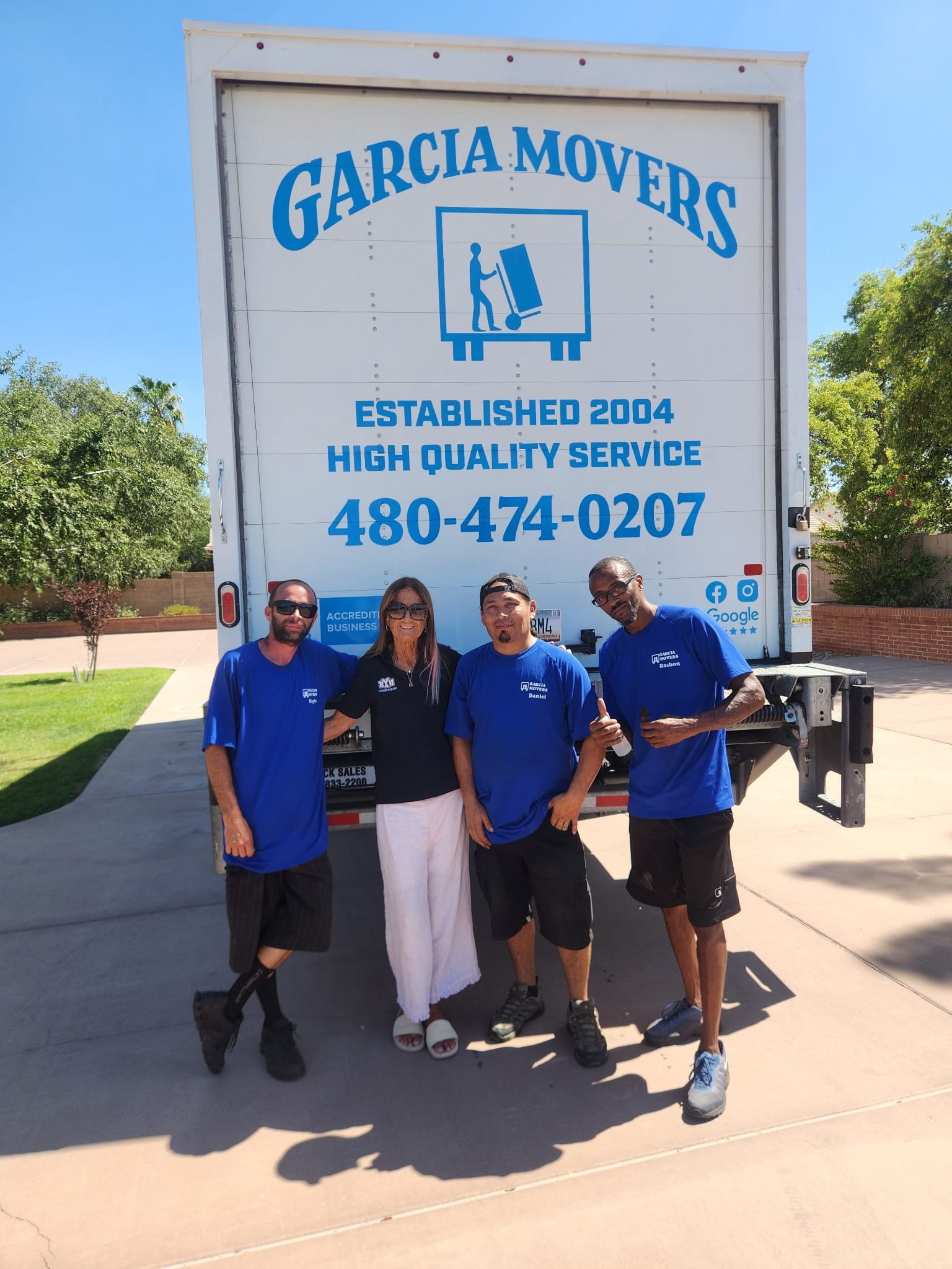 The Garcia Movers team at the back of a branded company truck, established 2004