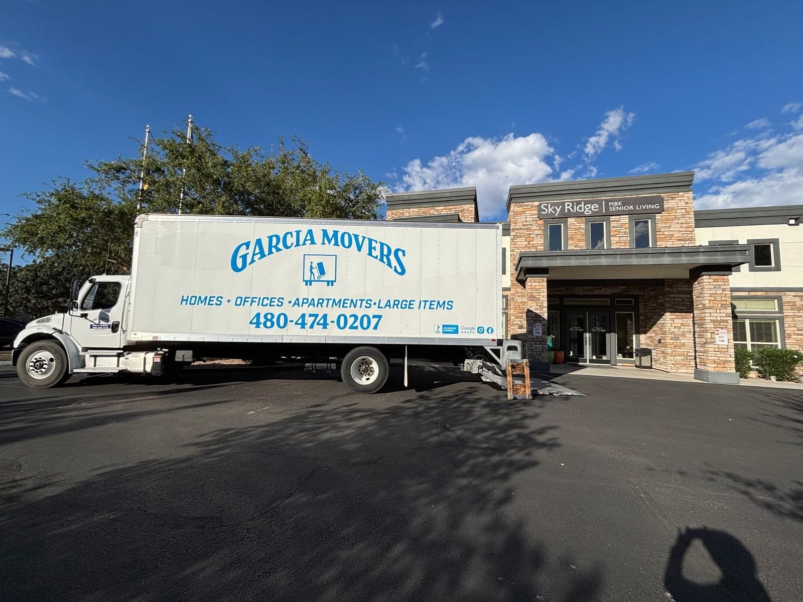A Garcia Movers truck at the entrance of a senior living community